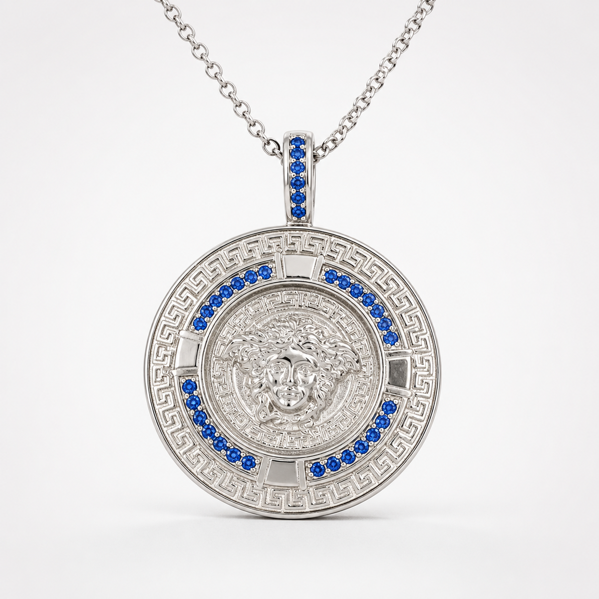 Professional studio product photo of Greek Key Mythology Medusa Pendant Blue CZ Stones + Sterling Silver Chain on white background