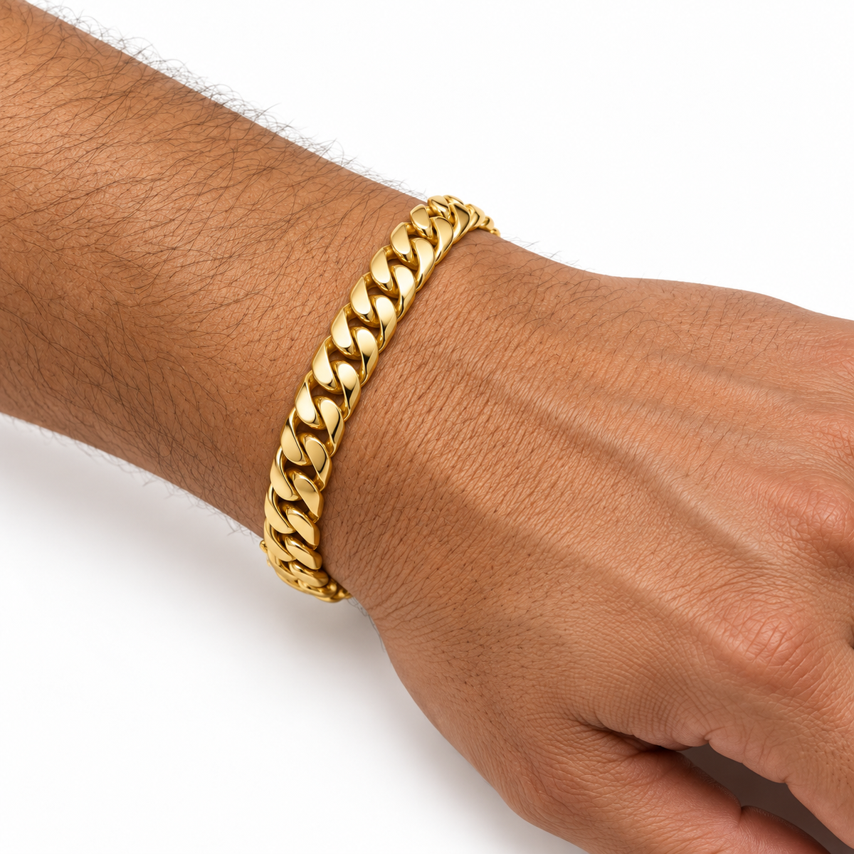 A close-up of a person's wrist and hand wearing a thick, shiny gold Cuban link chain bracelet against a plain white background.